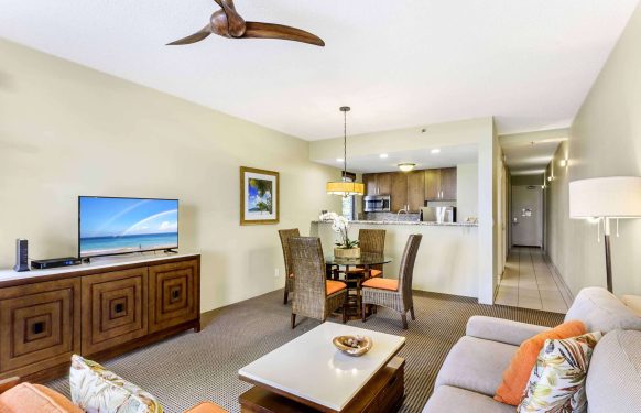 Open-plan one-bedroom suite in a Maui hotel featuring a living area, dining table, and kitchenette.